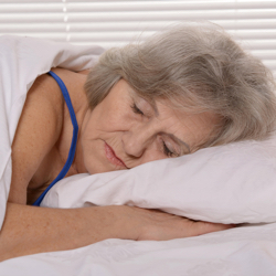 Elderly woman sleeping in bed.